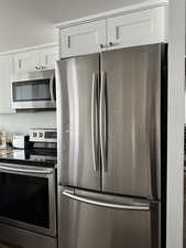 Kitchen featuring stainless steel appliances and white cabinetry
