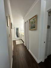 Hall featuring ornamental molding, dark wood-style flooring, and baseboards
