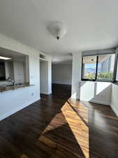 Unfurnished dining area with a textured ceiling and dark wood finished floors
