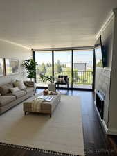 Living area with crown molding, plenty of natural light, a wall of windows, and dark wood finished floors