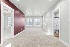 Spare room featuring carpet floors, baseboards, recessed lighting, and a smoke detector