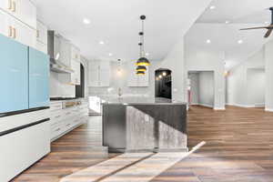 Kitchen with white fridge, ceiling fan, a center island, dark wood-style floors, and recessed lighting