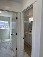 Bathroom with marble look tiles, vanity, baseboards, and a textured ceiling