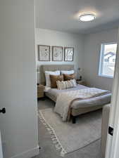Bedroom with a textured ceiling and carpet floors