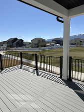 Wooden deck with a residential view, a yard, and a mountain view