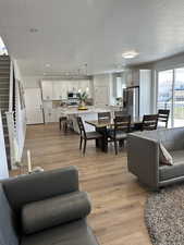 Living room featuring light wood-style floors, stairway, a textured ceiling, and recessed lighting