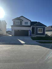 View of front facade featuring concrete driveway, an attached garage, and board and batten siding