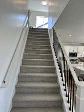 Stairway with recessed lighting and a textured ceiling