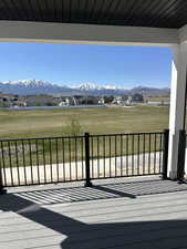 Wooden deck featuring a mountain view, a yard, and a residential view