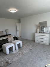 Bedroom with a textured ceiling, carpet flooring, and baseboards