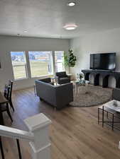 Living area with a textured ceiling, hardwood / wood-style flooring, plenty of natural light, and recessed lighting