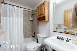 Main level Bathroom featuring a sink, toilet, and shower / bath combo with shower curtain
