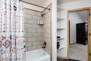 Bathroom with shower / bathtub combination with curtain and baseboards