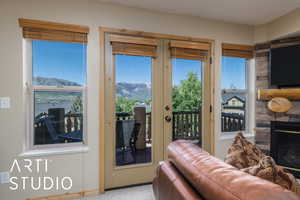 Doorway with a stone fireplace, carpet floors, a mountain view, and baseboards