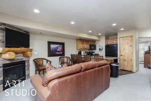 Living area featuring light colored carpet, a fireplace, recessed lighting, and a textured ceiling
