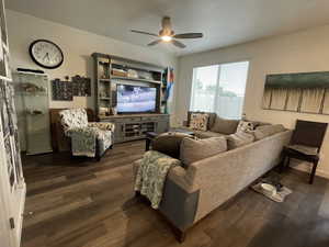 Living room with ceiling fan and dark wood finished floors