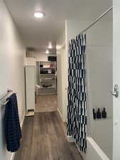 Hallway featuring dark wood-style flooring and baseboards