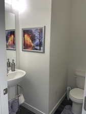 Half bathroom with toilet and baseboards
