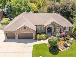 View of front facade with brick siding, a garage, concrete driveway, and a shingled roof