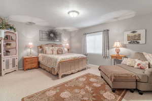 Another spacious bedroom with light carpet and lots of natural light.