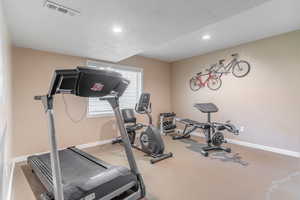 Workout room featuring cement finished floors and full closet that could also be used as an additional bedroom.