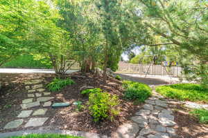 View of yard with pathways leading to 1/2 court basketball and playground area