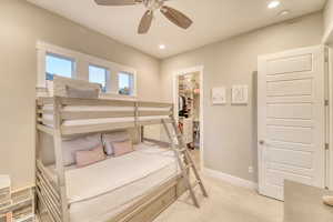 Bedroom with a walk in closet, light colored carpet, recessed lighting, a closet, and baseboards