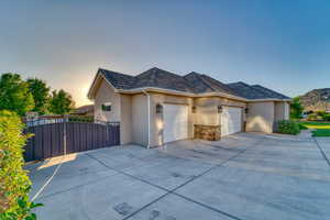 View of front of home featuring a garage, stucco siding, driveway, a mountain view, and a gate