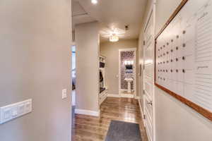 Hall featuring wood finished floors, baseboards, and mail area