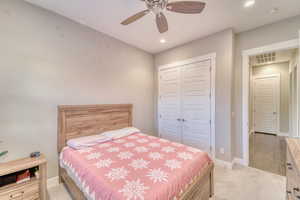 Bedroom with light carpet, a closet, baseboards, recessed lighting, and a ceiling fan