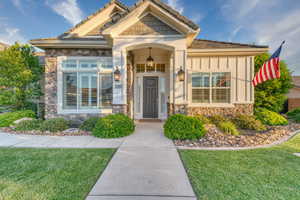 View of front of house featuring stone siding and a front yard