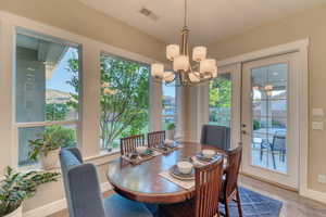Dining space with a chandelier, light wood-style floors, and baseboards