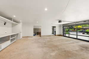 Garage featuring a garage door opener, recessed lighting, and baseboards