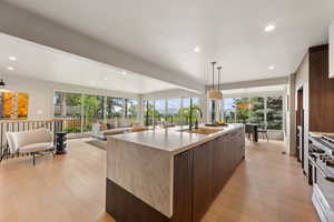 Kitchen featuring a sink, modern cabinets, high end range, light wood-style floors, and recessed lighting