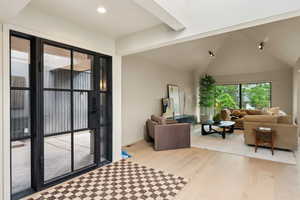 Living area with light wood-type flooring, lofted ceiling, recessed lighting, and baseboards