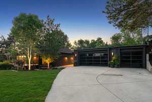 View of front of property with driveway, a front yard, and a wooden deck