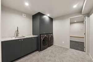 Laundry room with cabinet space, independent washer and dryer, recessed lighting, light tile patterned flooring, and baseboards