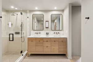Full bathroom with double vanity, a stall shower, recessed lighting, and baseboards
