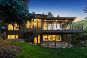 Rear view of property with stairway, a deck, and a yard