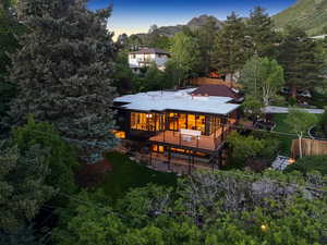 Back of property with a deck with mountain view and stairway