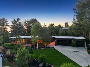 View of front of property featuring a lawn and concrete driveway