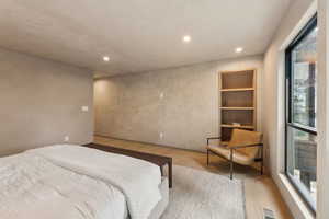 Bedroom with wood finished floors and recessed lighting