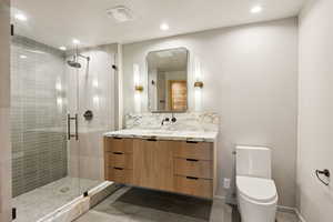 Bathroom featuring vanity, toilet, a stall shower, recessed lighting, and tile patterned floors