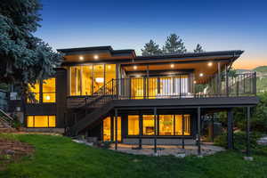 Rear view of property featuring stairway, a yard, central AC, and a deck