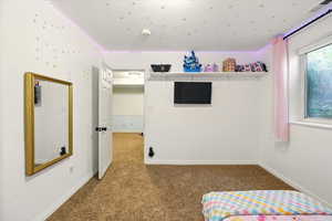Unfurnished bedroom featuring carpet and baseboards