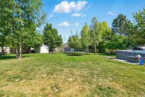 View of yard featuring a trampoline and an outdoor pool