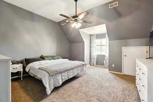 Bedroom featuring vaulted ceiling, light carpet, baseboards, and a ceiling fan
