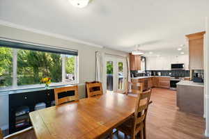 Dining room with ornamental molding, light wood finished floors, recessed lighting, and french doors