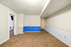 Carpeted empty room with baseboards and a textured ceiling