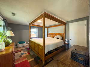 Tiled bedroom featuring a textured ceiling